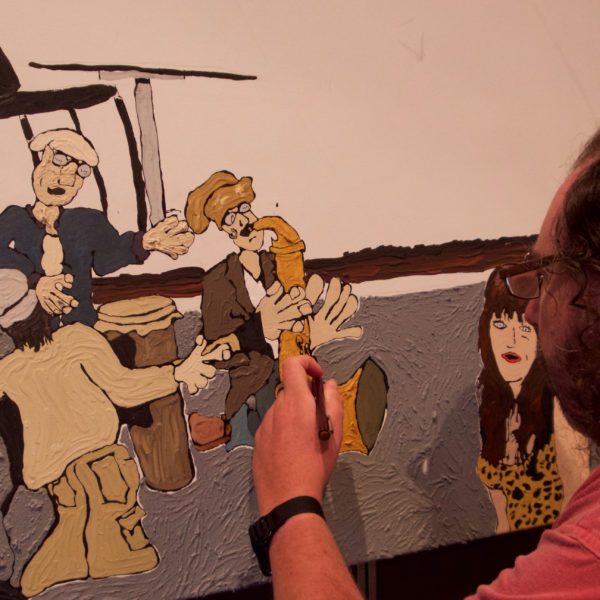 A man paints people playing music. 