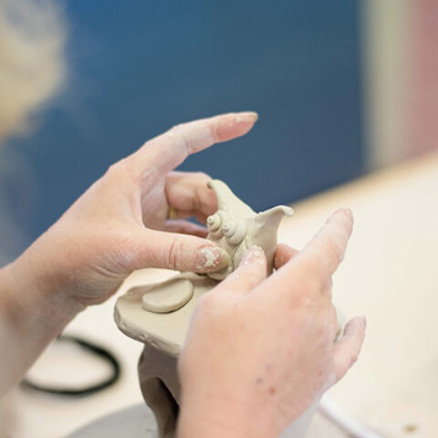 Hands sculpting clay