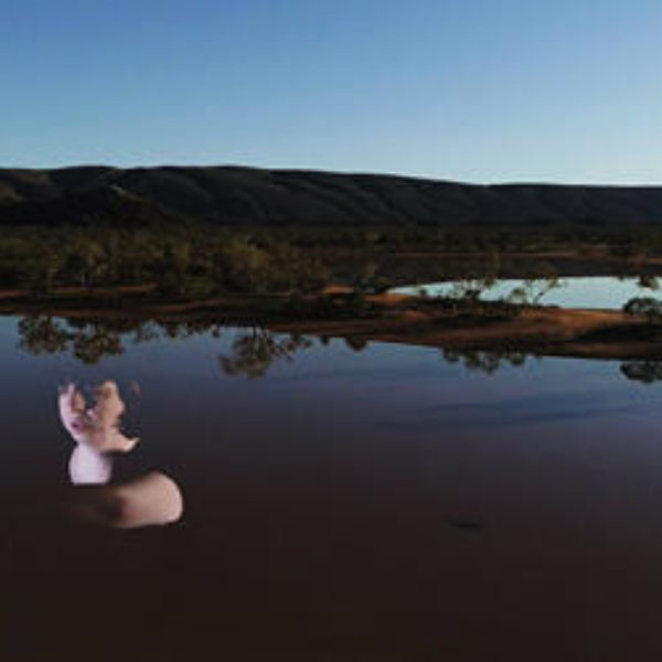Barely visible woman on large lake. hills in the background.