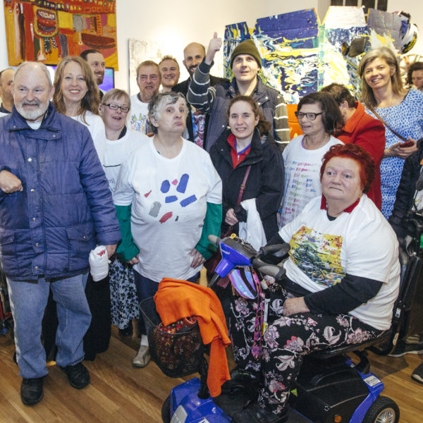 Art Day South artists in front of thier bringly coloured artwork. 