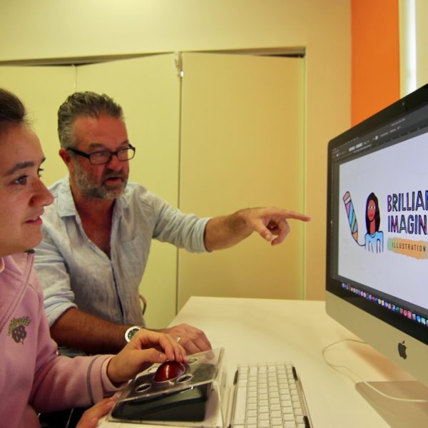A teacher showing a student how to use a computer