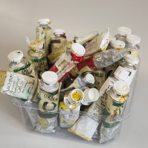 artists' paint tubes in a clear container