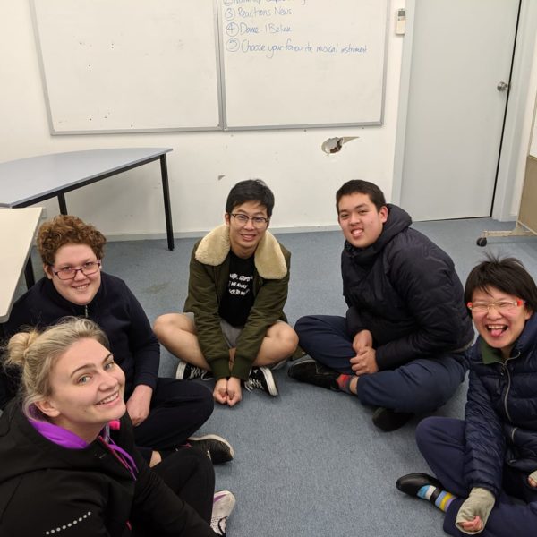 Small group sitting in a circle smiling