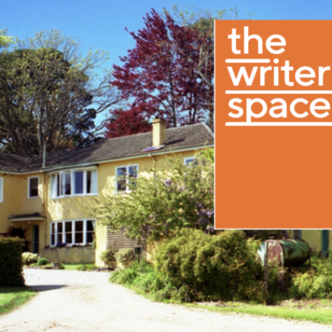 An image of a large yellow house in a garden. The words THE WRITERS SPACE appear in a lower case white font in the top right corner of the image. Behind these words is an orange rectangle.