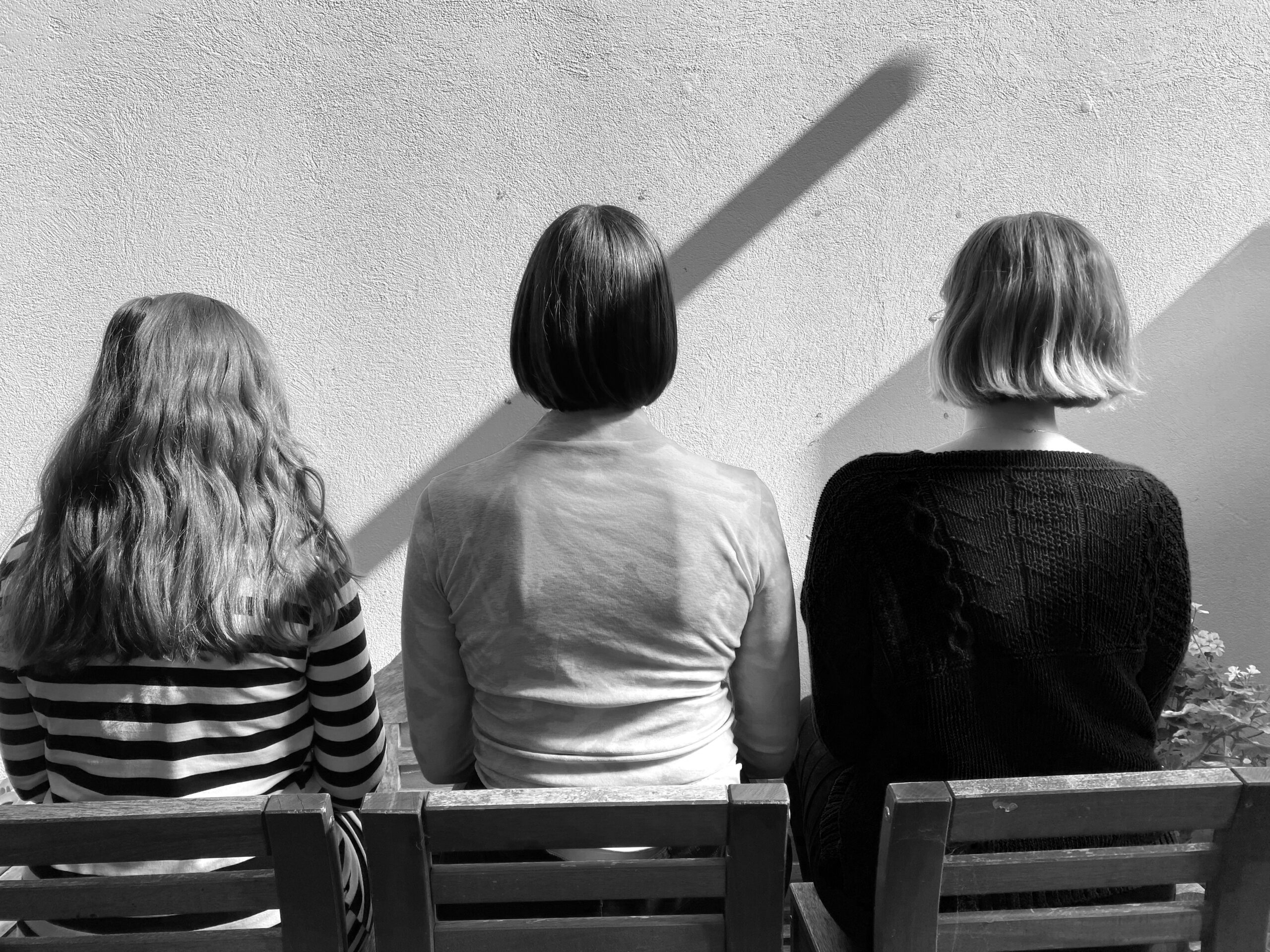black and white image of the back of three people