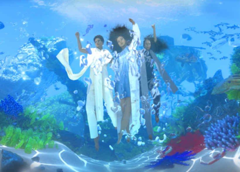 A digital rendering of three artists submerged in the water of a coral reef. A sunken ship is overgrown with sea plants/coral. Artists are suspended underwater, their hair is floating upward. There is coral in the foreground, and schools of fish billowing around them to the effect of cloth floating in water. 