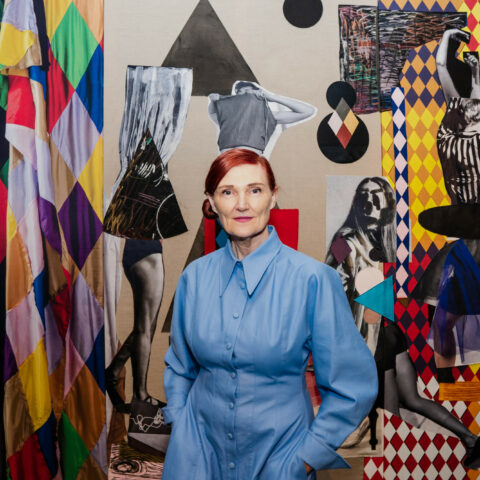 Portrait of Sally Smart standing in front of artwork