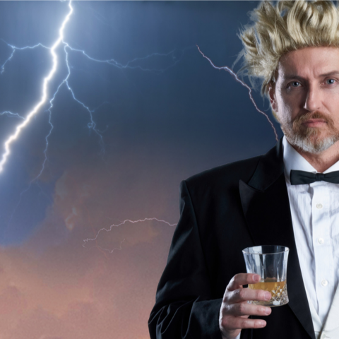 A man wearing a tuxedo stands holding a glass, with a stormy sky and lightning behind him. 