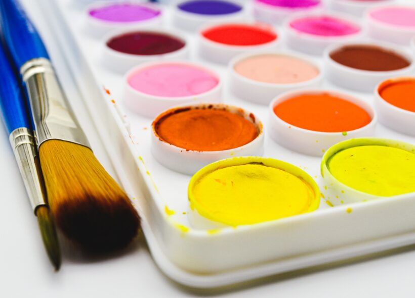 Paint pallet with colourful paints and brushes