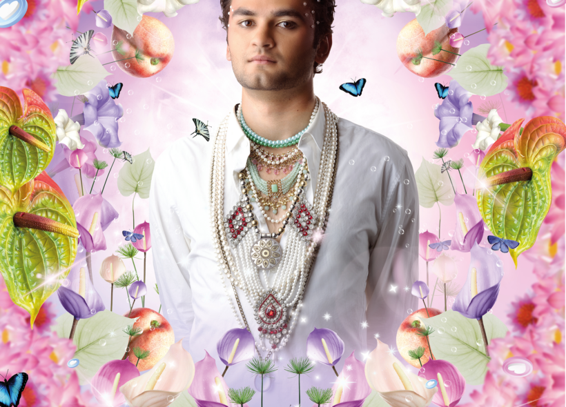 Raj Labade, dressed in a white shirt with layered jewellery, centred on a pink background surrounded by flowers, lillies, butterflies and peaches. 