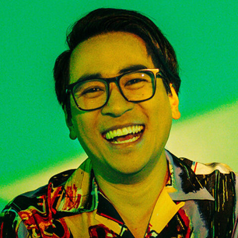 Headshot of Michael Hing in a very patterned shirt smiling at the camera