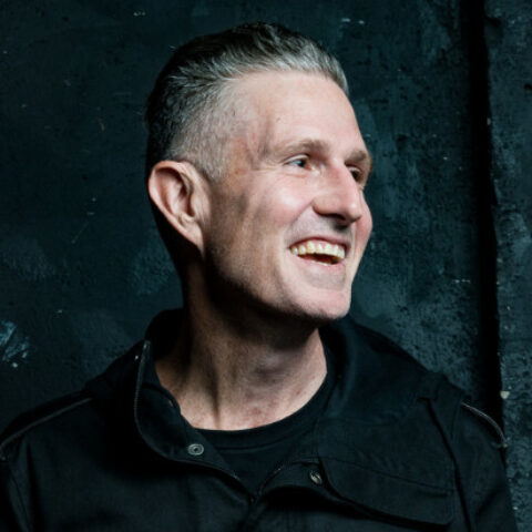 Headshot of Wil Anderson smiling off camera.