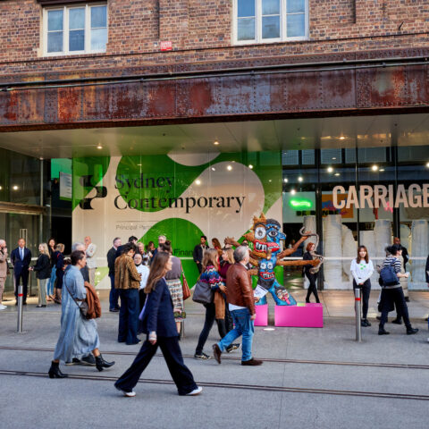 Group of people outdoors, walking into a venue with 'Sydney Contemporary, Carriageworks' written on it