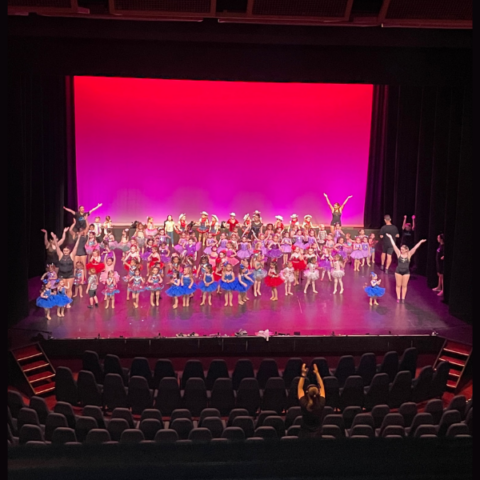Dance school on stage against a pink LED backdrop