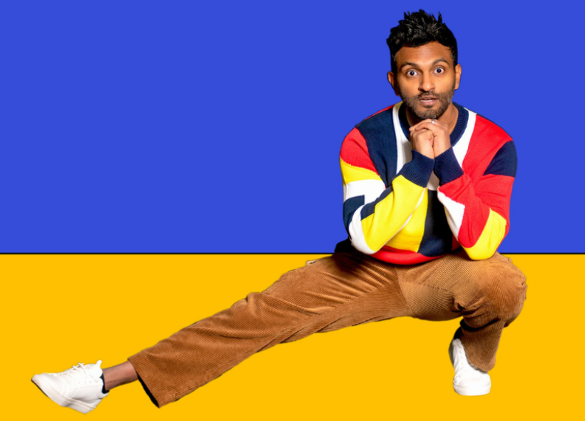 Man crouching on left leg with right leg extended out, blue and yellow backdrop.