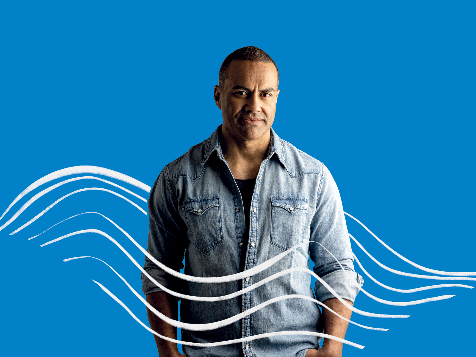 A man in a blue shirt looks to the camera with a stern expression. There are white wavy lines drawn over the image suggesting water or wind. There is a blue background. 