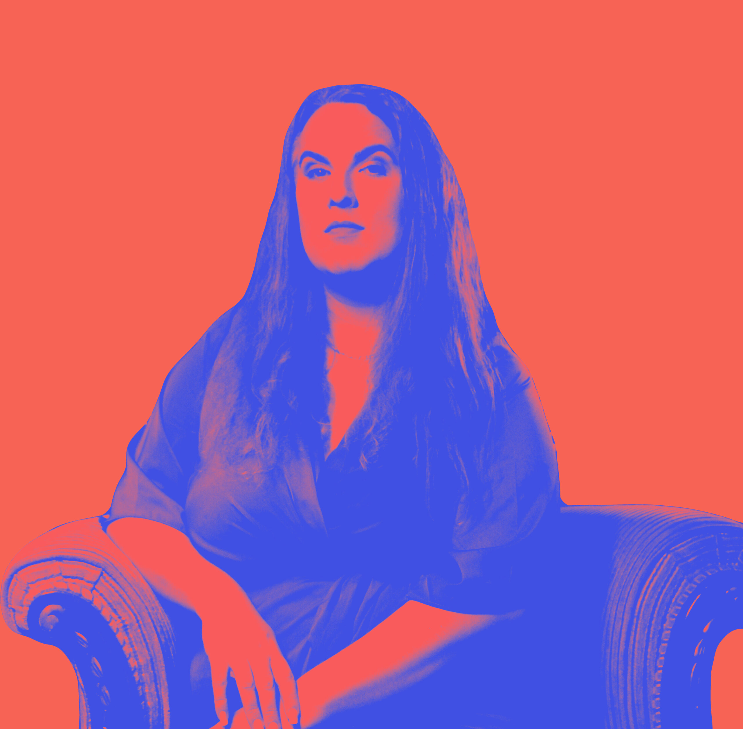 A duo-toned image of Anna Piper Scott as JK, the background is a hot orange and the person and arm chair are bright blue