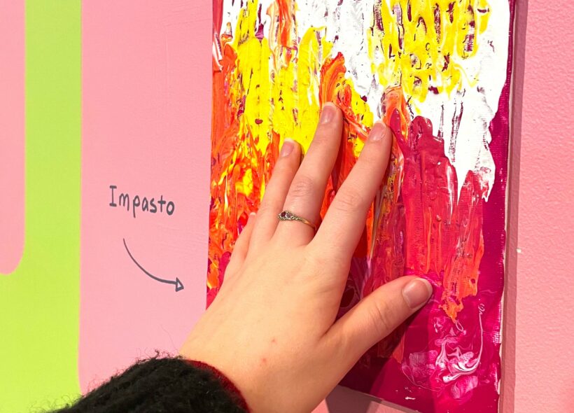 Hand touching small rectangular canvas board with impasto paint