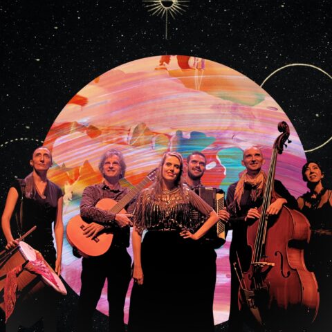 performers standing in front of giant planet backdrop
