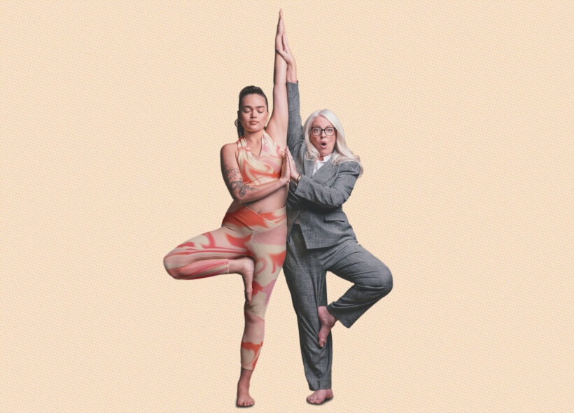 A mid-20s woman in activewear and an older lady in a grey suit complete a yoga pose together