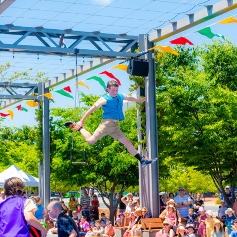 A kid is posing mid jump at  Borderville Festival outdoor performance