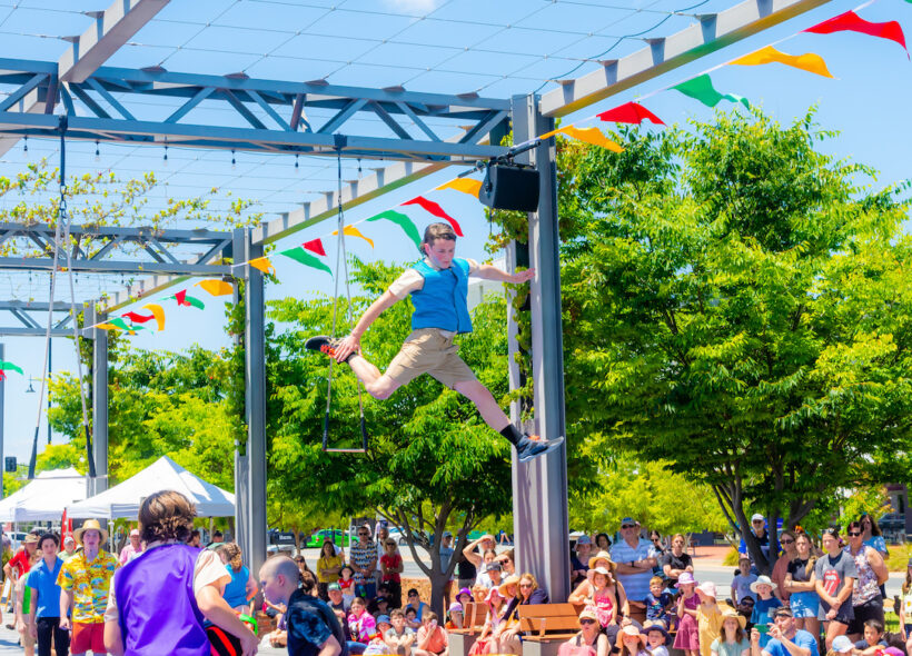 A kid is posing mid jump at  Borderville Festival outdoor performance