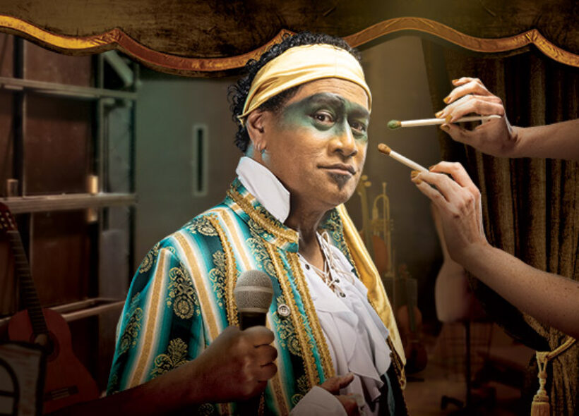 A pirate has green eye make up and a green jacket, with a yellow head band.