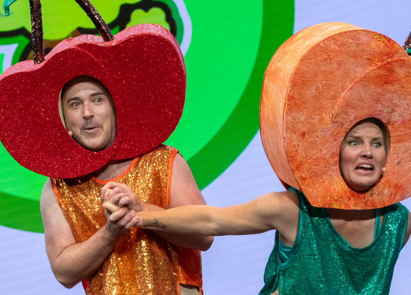 One actor in a apple costume, another in a peach costume, mid action 