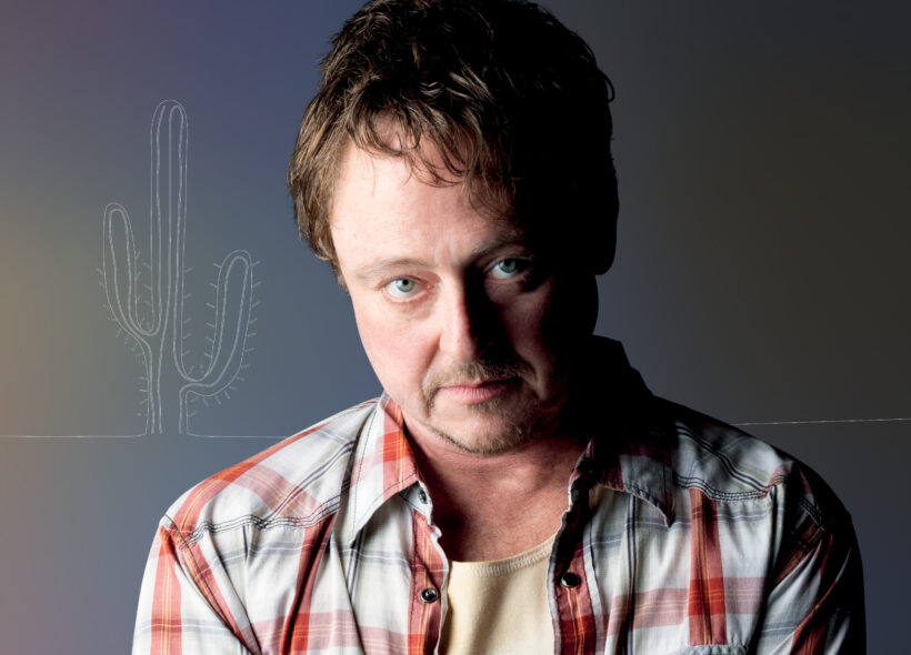 man wearing checkered shirt looking menacingly at the camera