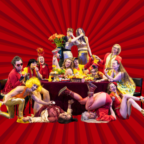 A group of women having a lavish banquet wearing red and yellow circus costumes.