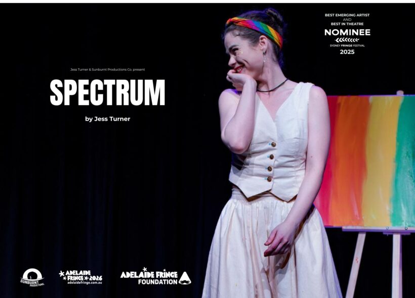 Promotional poster for the stage show “SPECTRUM” by Jess Turner. A smiling performer stands on a dark theatre stage, wearing a cream vintage-style dress with buttons down the front, black stockings, and black shoes. She has her hair in a bun with a rainbow headband and rests her hand against her cheek in a playful, bashful pose.  Behind her is an easel displaying a canvas painted in warm gradient tones (red, orange, yellow).  Text on the image reads: “Jess Turner & Sunburnt Productions Co. present SPECTRUM by Jess Turner.” “Best Emerging Artist and Best in Theatre Nominee – Sydney Fringe Festival 2025.”  Logos along the bottom include Sunburnt Productions, Adelaide Fringe 2026 (adelaidefringe.com.au), and Adelaide Fringe Foundation.