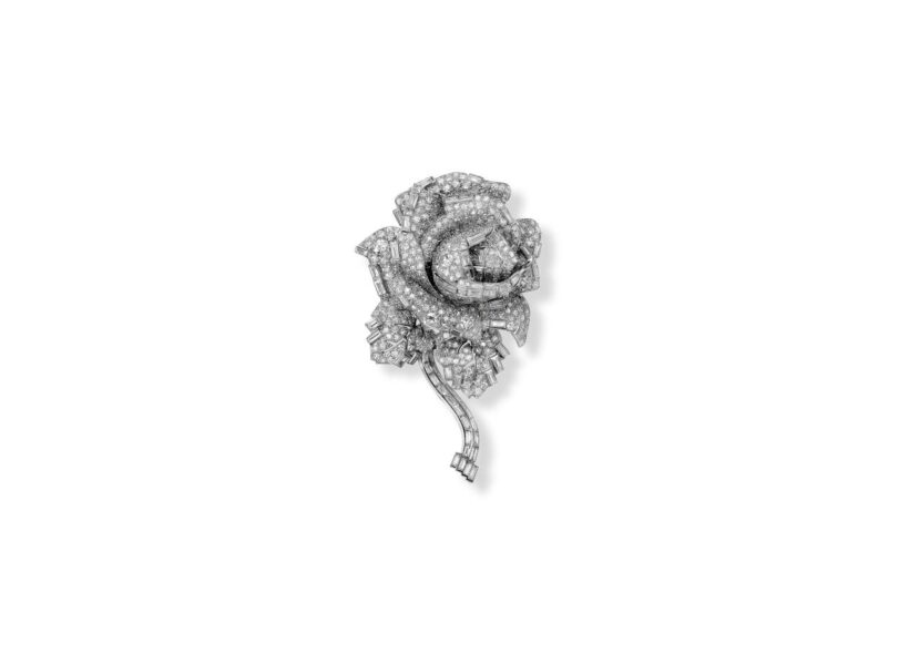 A photograph of a brooch in teh shape of a rose, with small diamonds covering every surface. 