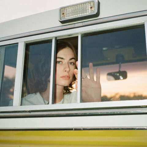 Canadian-American sound artist and composer claire rousay stares to camera while seated in a vintage car