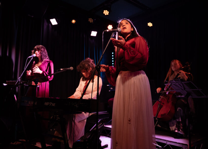 A lively performance by women, harmonizing together on stage, radiating joy and energy