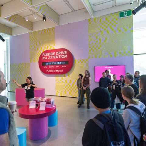 Large group participating in Auslan tour in colourful gallery space. 