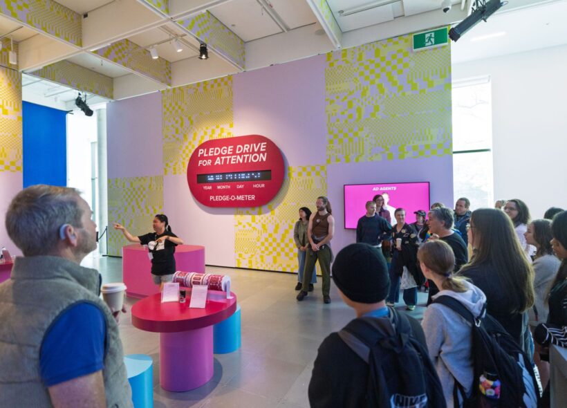 Large group participating in Auslan tour in colourful gallery space. 