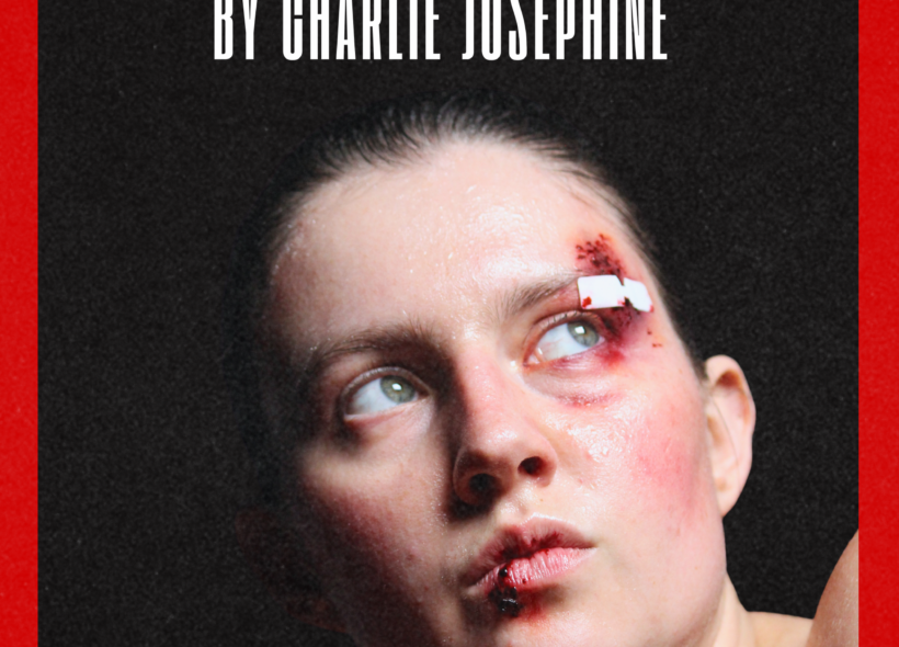 A photo of a sweaty bruised female boxer looking at the ceiling.