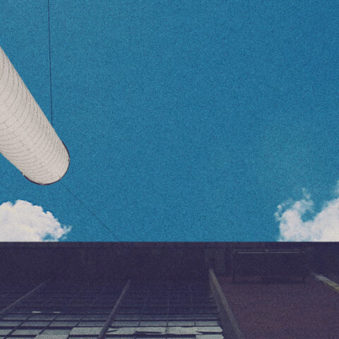 building and pipes reaching towards a blue sky 
