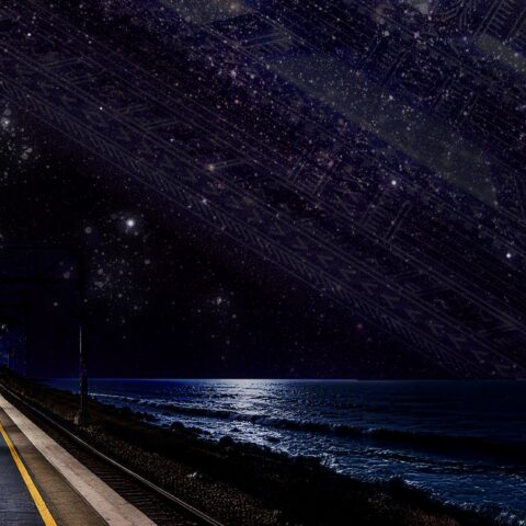 An empty Western Line platform stretches beside a dark ocean under a brilliant, star-filled sky, creating a quiet, dreamlike nighttime scene.